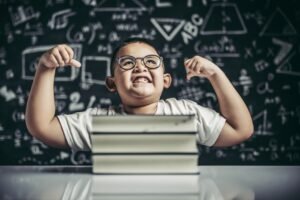 boy with glasses sitting study with both armsperpendicular